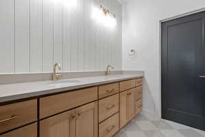 Bathroom featuring double vanity and light floors