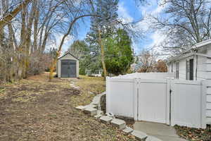View of yard featuring a shed and a gate
