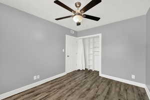 Unfurnished bedroom with dark wood-style floors and ceiling fan