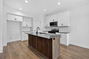 Dual tone kitchen with stainless steel appliances, tasteful backsplash, dual tone cabinetry, dark wood-style floors, and recessed lighting