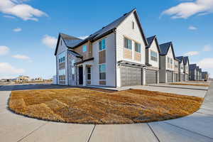 View of front of property with concrete driveway, an attached garage, a residential view, and a front lawn