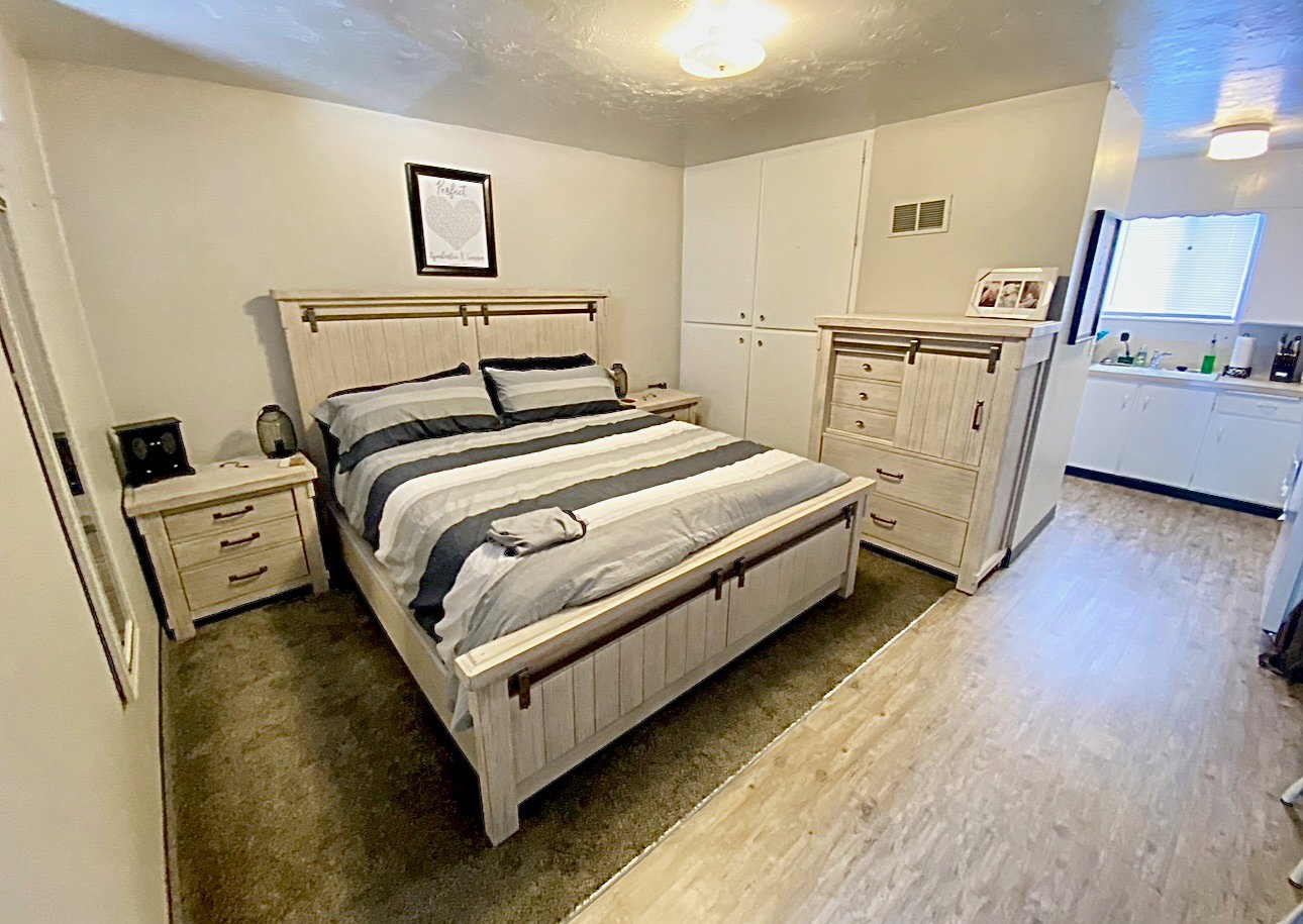 Bedroom with dark wood-type flooring, a closet, and a textured ceiling