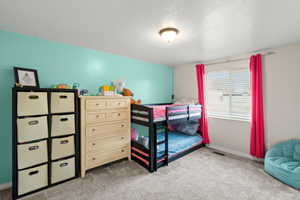 Bedroom featuring light carpet
