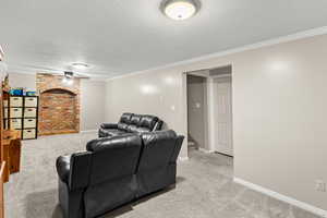 Cinema room featuring a ceiling fan, crown molding, light carpet, and a textured ceiling