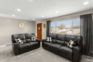 Carpeted living area featuring recessed lighting and baseboards