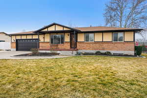 Ranch-style home featuring concrete driveway, an attached garage, brick siding, and covered porch