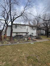 Back of house featuring a patio area, a lawn, and an outdoor fire pit