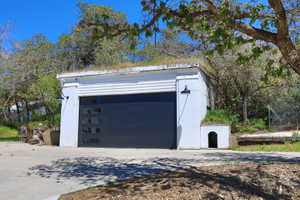 Attached garage with a contemporary dark gray door featuring horizontal window panels, flanked by two exterior wall sconces