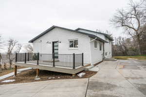 Back of property featuring a wooden deck and brick siding