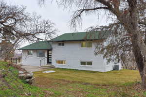 Back of house featuring brick siding and a yard