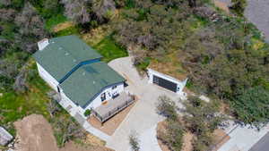 Contemporary exterior with a green shingle roof, light-colored siding, and a spacious elevated deck