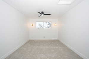 Empty room featuring carpet floors and a ceiling fan
