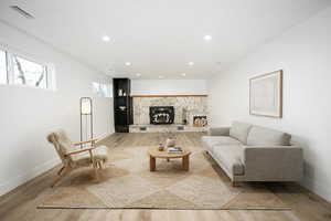 Living room featuring a fireplace, recessed lighting, and light wood-style floors