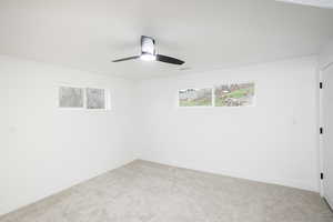 Unfurnished room featuring light colored carpet and ceiling fan