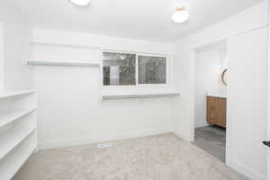 Unfurnished bedroom featuring light carpet, a textured ceiling, and connected bathroom