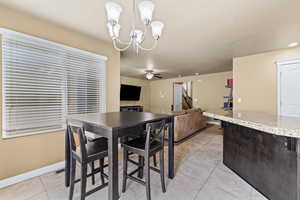 Dining room with light tile patterned flooring, suspended lighting, and ceiling fan