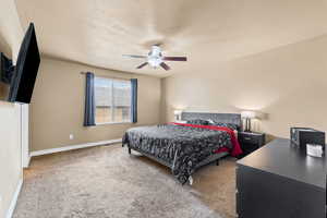 Bedroom featuring carpet flooring, ceiling fan, and a textured ceiling