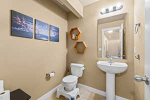 Half bathroom with toilet and light tile patterned floors