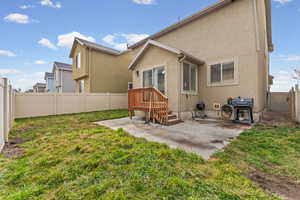 Back of property featuring a fenced backyard, a patio area, and stucco siding