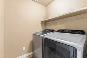 Laundry room with baseboards and washer and dryer