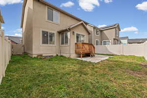 Rear view of house with a gate, stucco siding, a fenced backyard, a patio area, and a deck