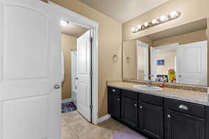 Full bath featuring vanity, light tile patterned floors, and bathtub / shower combination
