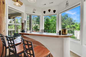 Bar with light countertops and light wood-style floors