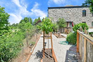Fenced yard featuring a wooden deck and a vegetable garden
