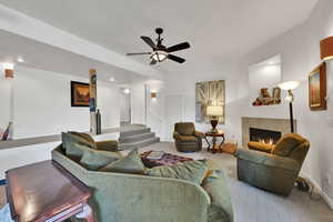 Living room with a tile fireplace, a ceiling fan, and recessed lighting