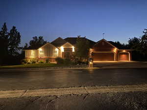 View of front of property featuring an attached garage, board and batten siding, and driveway