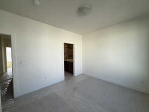 Unfurnished bedroom featuring carpet flooring and ensuite bath