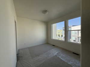 Carpeted spare room featuring baseboards