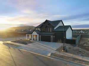 View of front facade with an attached garage, board and batten siding, driveway, and a mountain view