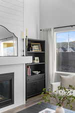 Detailed view of wood finished floors and a glass covered fireplace