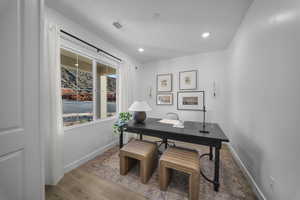 Office with wood finished floors and recessed lighting