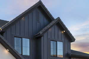 View of side of home featuring board and batten siding and roof with shingles