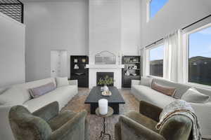 Living room with a high ceiling and a large fireplace