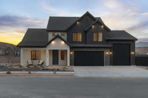 Modern inspired farmhouse with driveway, covered porch, board and batten siding, and a garage