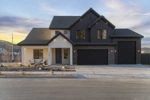 Modern farmhouse style home with covered porch, board and batten siding, driveway, and an attached garage