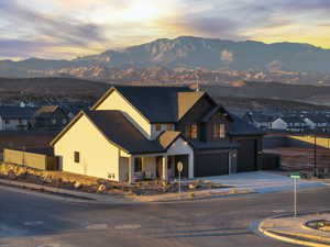 View of front of house with a mountain view, concrete driveway, covered porch, a garage, and a residential view