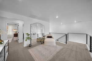Living area featuring carpet floors and an upstairs landing