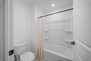 Full bath with toilet and shower / bath combination with curtain