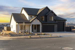 Modern farmhouse style home with a porch, board and batten siding, a mountain view, and driveway