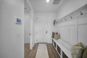 Mudroom with light wood-style flooring and baseboards