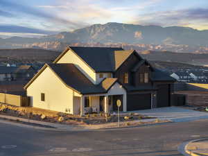 View of front of house featuring a mountain view, board and batten siding, concrete driveway, a porch, and an attached garage