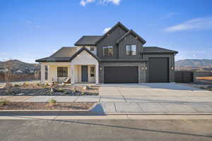 Modern inspired farmhouse with a mountain view, a porch, driveway, board and batten siding, and a garage
