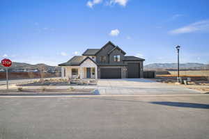 Modern inspired farmhouse featuring a mountain view, a porch, board and batten siding, and stone siding