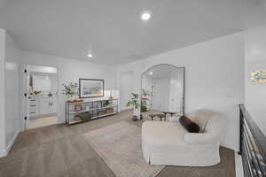 Living area featuring light carpet and recessed lighting