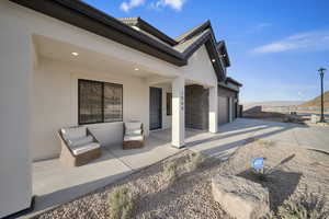 View of patio with concrete driveway, a mountain view, and a garage