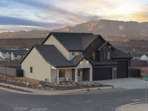 View of front of home featuring a mountain view, covered porch, concrete driveway, and board and batten siding